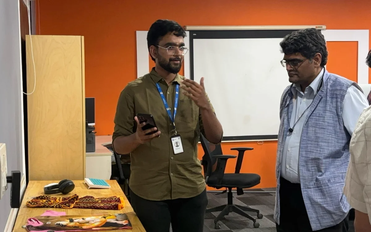 A team member demonstrates e-VikrAI on a phone at our office at IIIT Hyderabad, with products laid out on the table