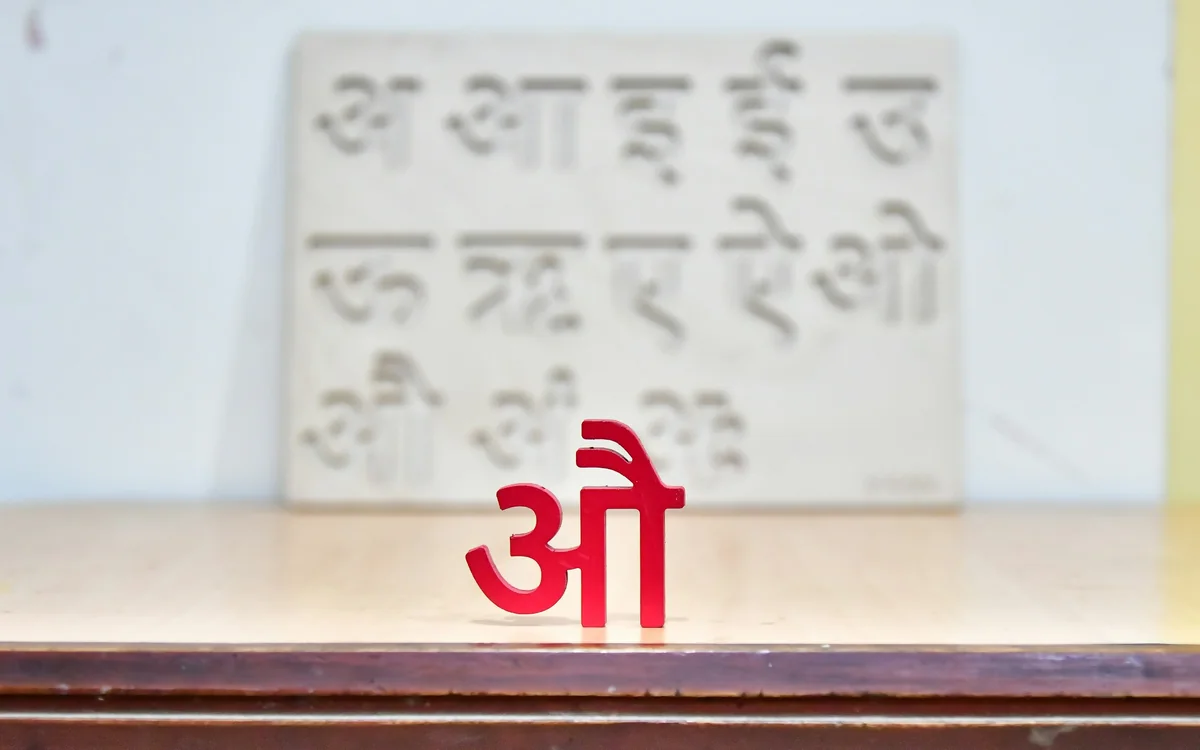 A wooden board of Hindi vowels, with a red औ standing in front. Photo: Rohan Solankurkar, Unsplash
